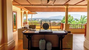 A covered outdoor seating area with a view of mountains and greenery.