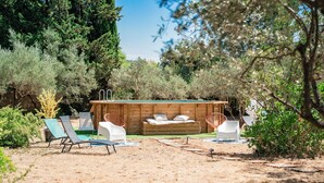 A wooden cabin with a built-in hot tub, surrounded by trees and a dry, grassy area. - Cotignac en famille - the perfect setting for your vacation (Cotignac)