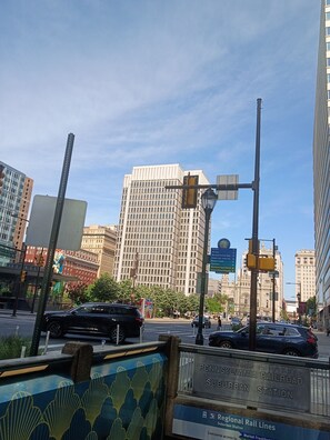 Una calle de la ciudad con un letrero de la estación Suburban de Pennsylvania Railroad, edificios altos y semáforos.