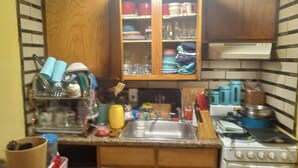 Una cocina con armarios de madera, un lavabo y una estufa.