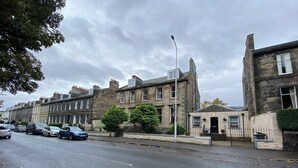 A row of terraced houses with a pub named "Hermitage Place" in front.