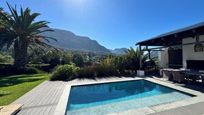 A swimming pool with a view of mountains, surrounded by greenery and a patio area. - Private Villa with pool in Cape Town (Cape Town)