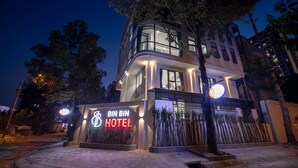 A modern hotel with a prominent entrance, large windows, and a well-lit facade. - Bin Bin Hotel 15 - Near Feliz En Vista (Ho Chi Minh City)