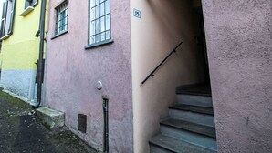 Un edificio con fachada rosa, un número '15' visible en la pared, y una barandilla metálica en las escaleras.