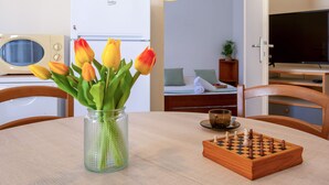 Una mesa de comedor con un tablero de ajedrez y un jarrón de tulipanes.