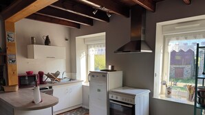 A compact kitchen with a built-in oven, a microwave, and a refrigerator.