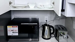 A kitchen with a microwave, toaster, and coffee maker on the counter.