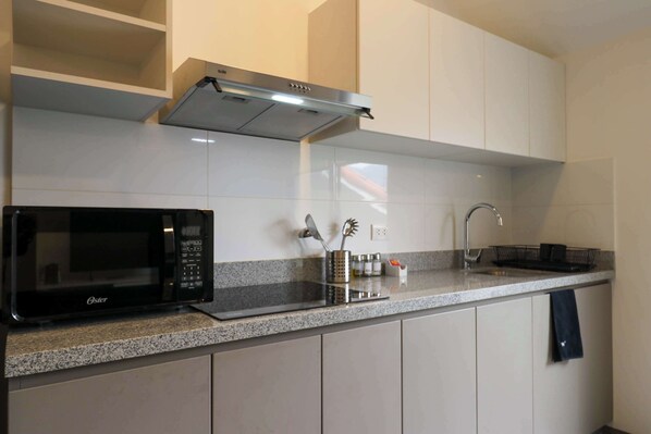 Kitchen features a stainless steel range hood, microwave, and granite countertop.
