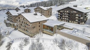 A modern ski resort with multi-story buildings, ski lifts, and snow-covered trees. - Apartment in Hauteluce With Ski-in/ski-out Access (Hauteluce)