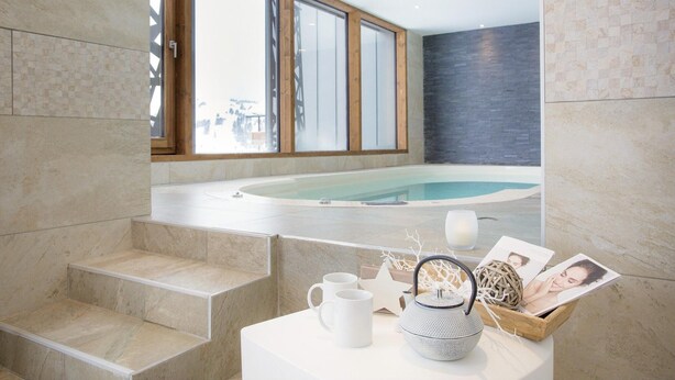 A modern bathroom with a large bathtub, marble steps, and a view of the ocean. - Apartment in Hauteluce With Ski-in/ski-out Access (Hauteluce)