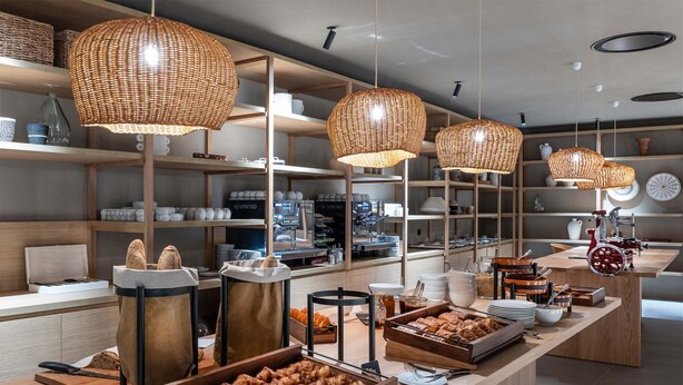 A breakfast buffet with wicker pendant lights, wooden tables, and a variety of food items. - Apartment in Baillargues With Heated Pool (Baillargues)