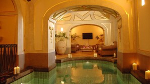 Un espacio de spa con piscina, asientos y velas.