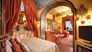 Un dormitorio lujoso con una cama grande, un televisor y vista al mar.