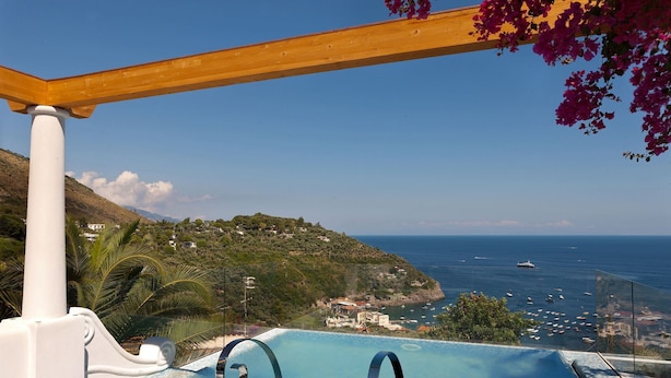 An infinity pool with a view of the sea and a hillside. - Villa delle Sirene with pool - My Rental Homes (Massa Lubrense)