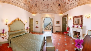 A spacious bedroom with a large bed, a fireplace, and a view through a doorway. - Villa Elyseum with swimming pool - My Rental homes (Positano)
