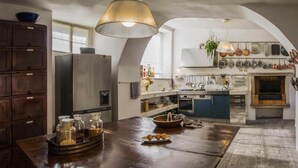 Una cocina con una isla central, electrodomésticos de acero inoxidable y varios utensilios de cocina colgados en la pared.