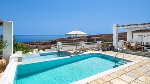 A rooftop pool with clear blue water, white poolside furniture, and a view of the sea. - My Rental Homes - Villa Tramountana with pool and large outdoor spaces with BBQ (Fira)