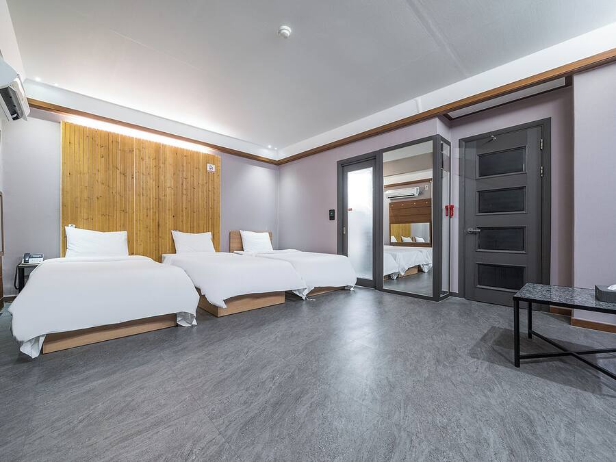 Ein Hotelzimmer mit zwei Betten, einem kleinen Tisch und einem Spiegel.