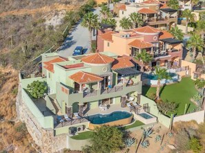 Un immeuble résidentiel à plusieurs étages doté d’une piscine, de balcons et d’un jardin aménagé.