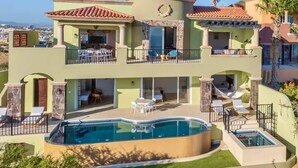 Une maison à deux étages avec une piscine, un espace extérieur aménagé et une vue sur la ville.