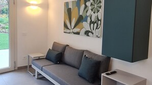 Una sala de estar moderna con un sofá, una mesa de centro y un cuadro en la pared.