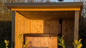 A wooden sauna structure with a bench and a heater. - Not Available for Rent (Whitchurch)