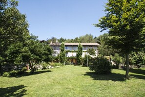 A two-story building with a garden in front.