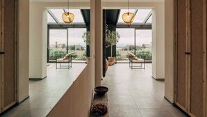 A modern interior with a central corridor leading to a seating area with a view. - Casa Upupa - Luxury Villa in Tuscany (Toscana)