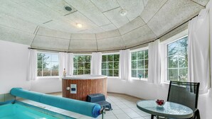 Un espace bien-être comprenant une piscine, une table de massage et un jacuzzi.