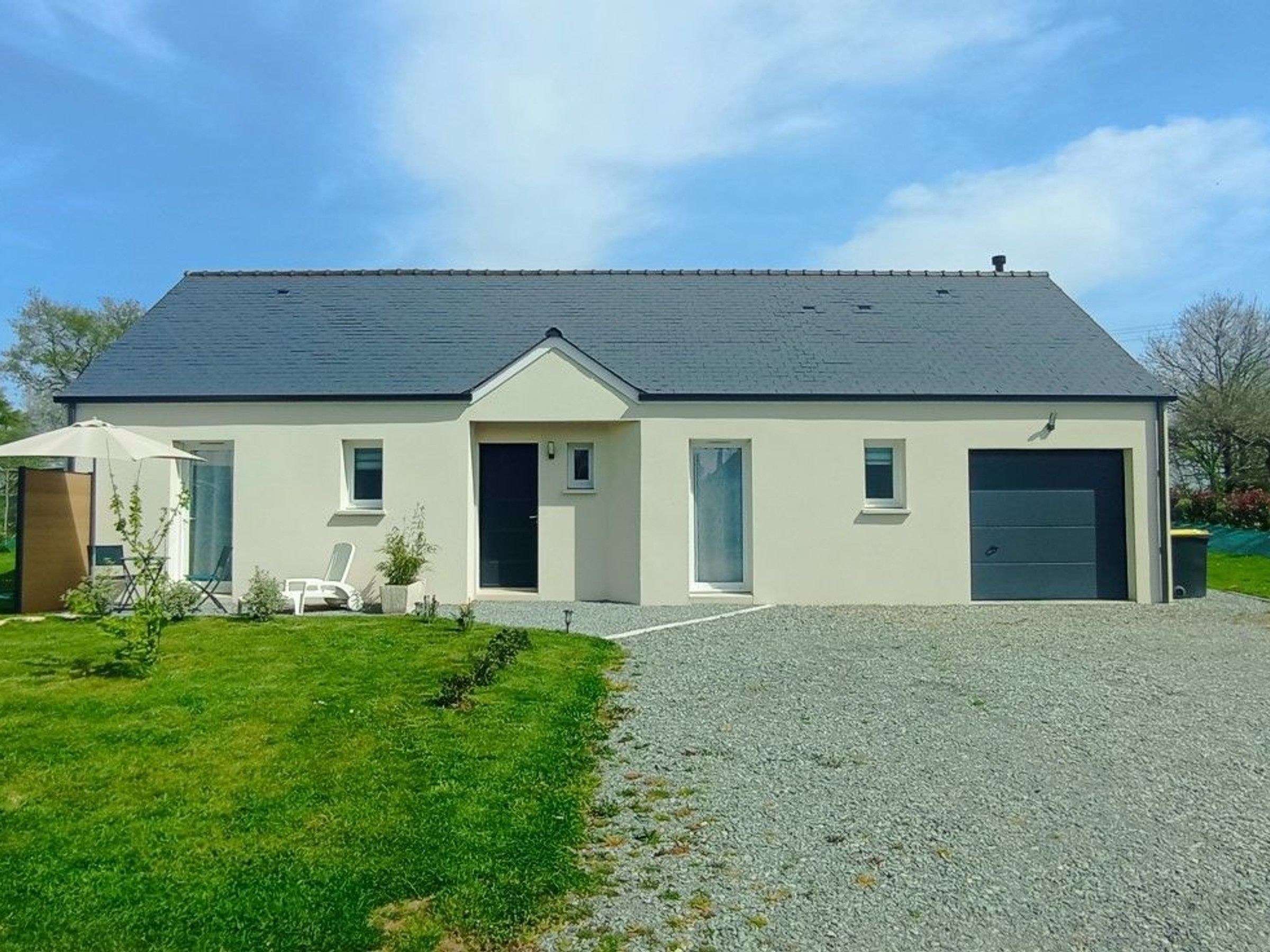 Ein modernes, zweistöckiges Haus mit Garage, überdachter Terrasse und gepflegtem Rasen.
