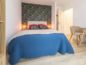 A bedroom with a bed, a nightstand, a chair, and a door. - Cozy room with private terrace and wifi in Missillac (Missillac)