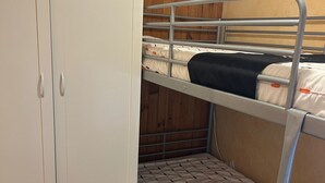 A bunk bed room with a wardrobe and a bed with a patterned bedspread. - Cozy studio on Super Besse slopes (Besse-et-Saint-Anastaise)