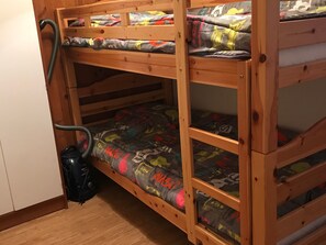 A bunk bed with a vacuum cleaner and a suitcase.