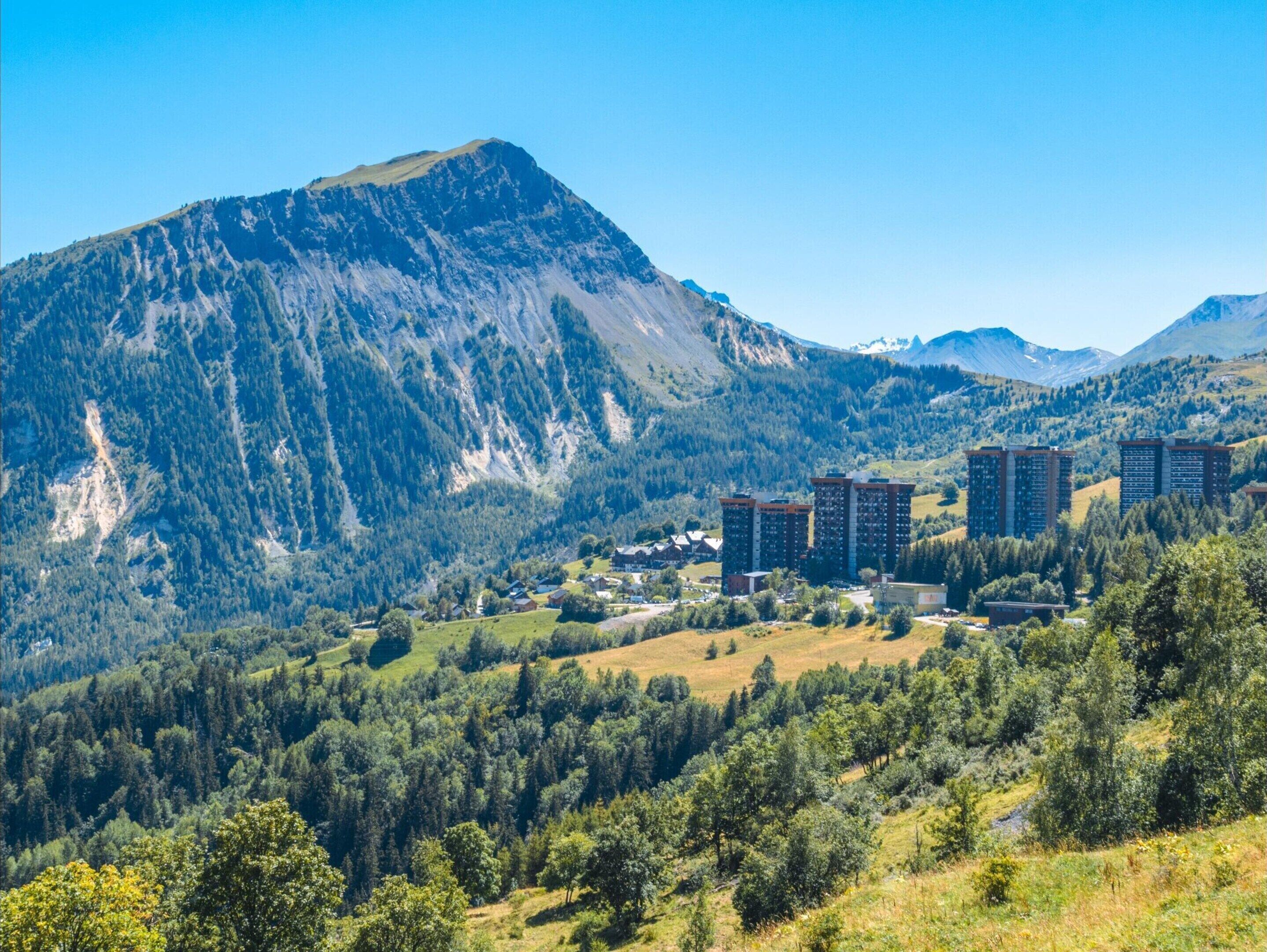 A mountainous landscape with residential buildings and a clear sky.