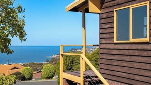 Una casa de madera con balcón y vistas al mar.
