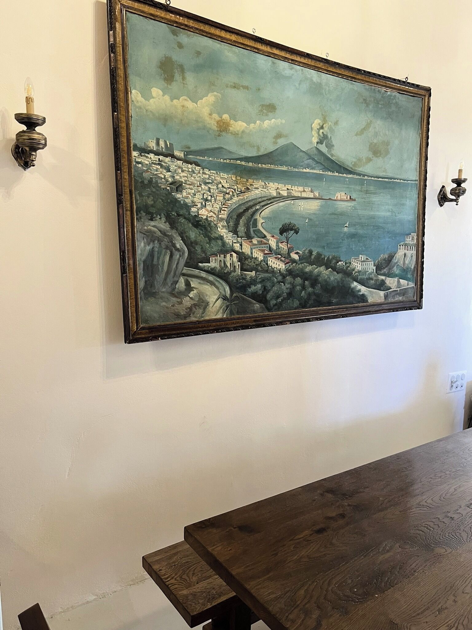 A painting of a coastal cityscape with a table in the foreground.