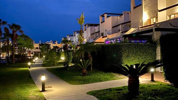 A nighttime view of a modern residential area with well-lit pathways and buildings. - 3 Bedroom Apartment on Golf Resort with Pool (Alhama de Murcia)