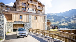 A multi-story wooden building with balconies, a stone facade, and a sign for "PARKING NORD". - Apartment in Les Menuires With Spa & Pool (Les Belleville)