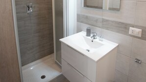 A modern bathroom with a walk-in shower, a white vanity, and a mirror above the sink. - ROOMS MONTEVERDE 2 (Rome)