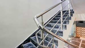 Una escalera moderna con barandilla de metal y escalones de mármol.