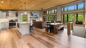 Une cuisine spacieuse avec des meubles en bois, un îlot central et une cheminée en pierre.