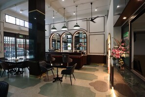 A lobby with a reception desk, seating area, and large windows. - Vintana Siam Hotel Bangkok (Bangkok)