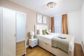 Une chambre à coucher avec un lit, une table de chevet et une armoire.