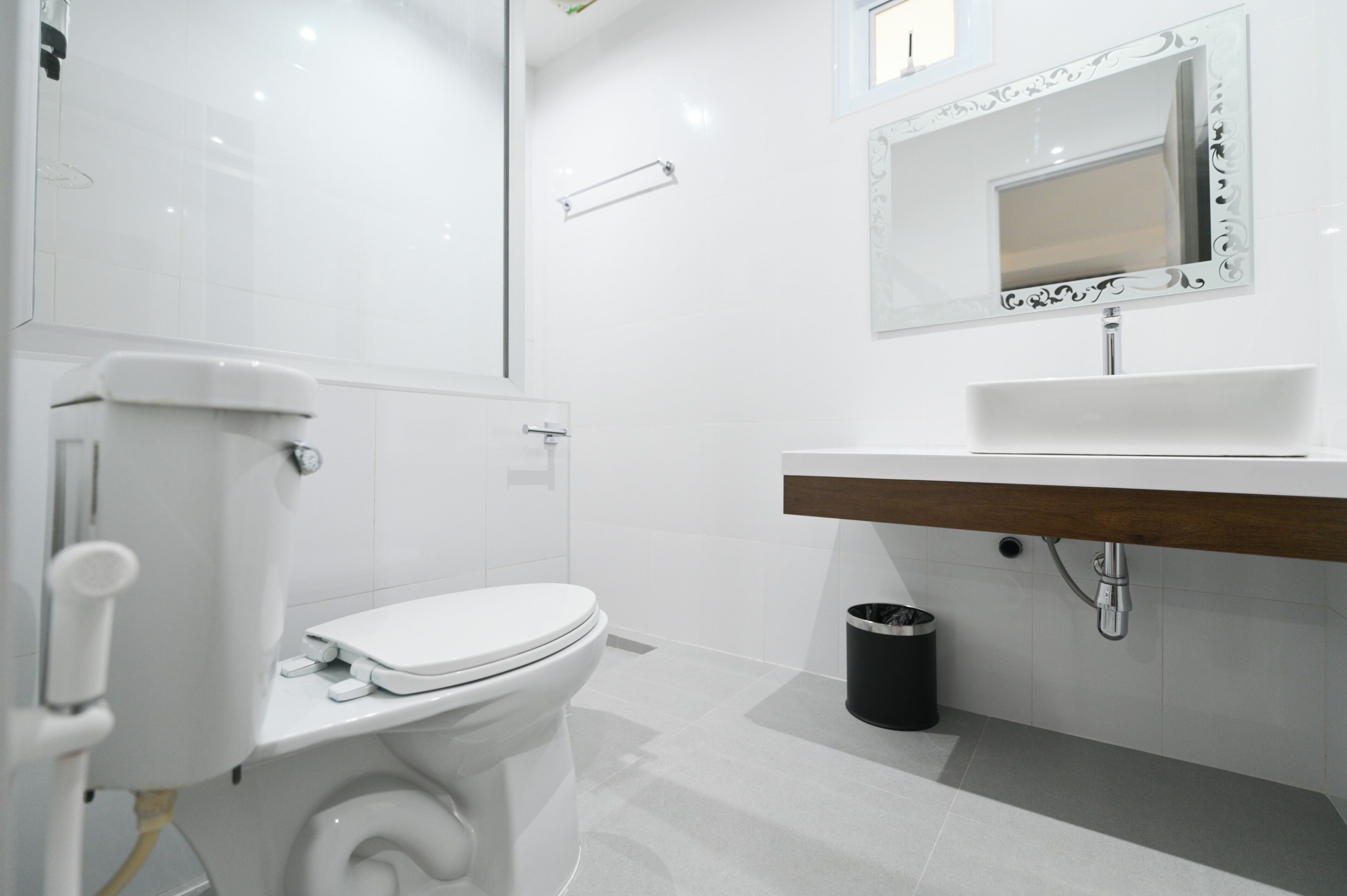 A modern bathroom with a toilet, sink, and mirror.