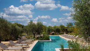 A rectangular pool with clear blue water, surrounded by lounge chairs and greenery. - Apartment in Baillargues Near Golf Course (Baillargues)