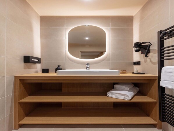 A modern bathroom with a large sink, wooden shelves, a towel rack, and a hairdryer. - Apartment in Baillargues Near Golf Course (Baillargues)