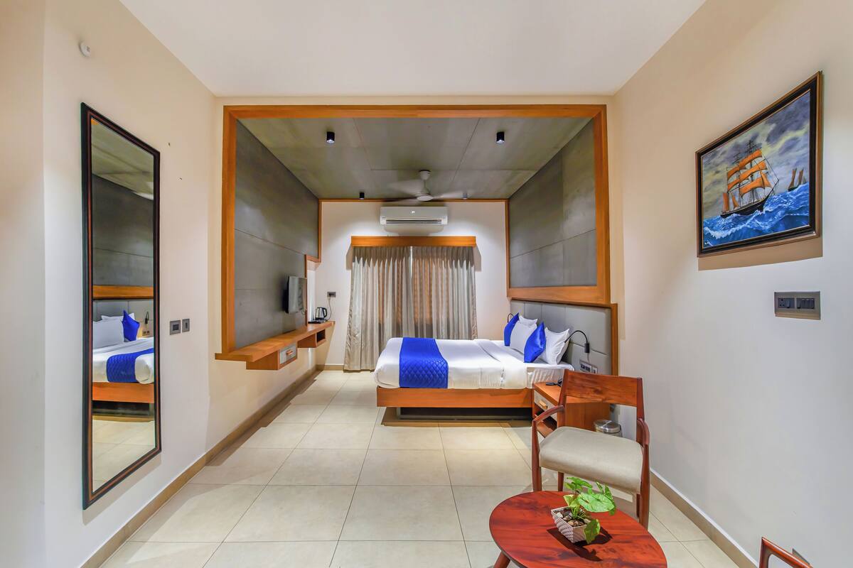 Une chambre d’hôtel avec un lit, un bureau, une chaise, une télévision et un tableau au mur.