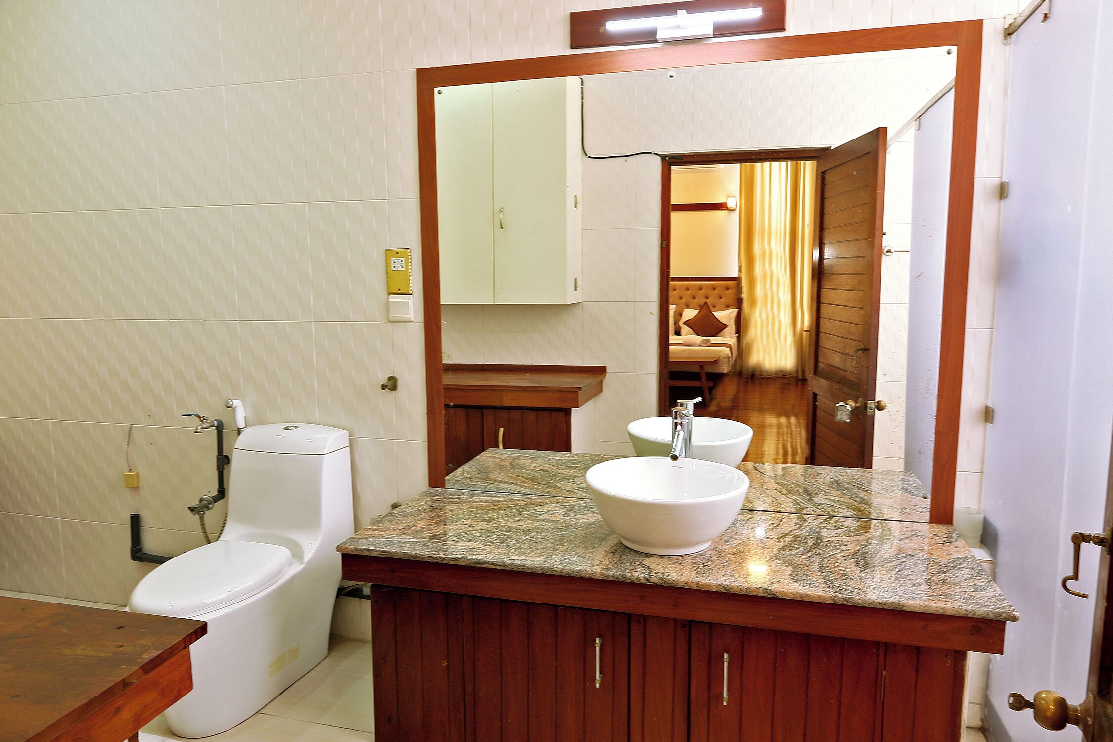 A bathroom with a toilet, a sink, and a mirror.