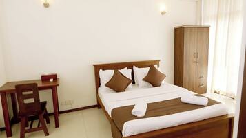 A bedroom with a wooden bed, a desk, and a chair.