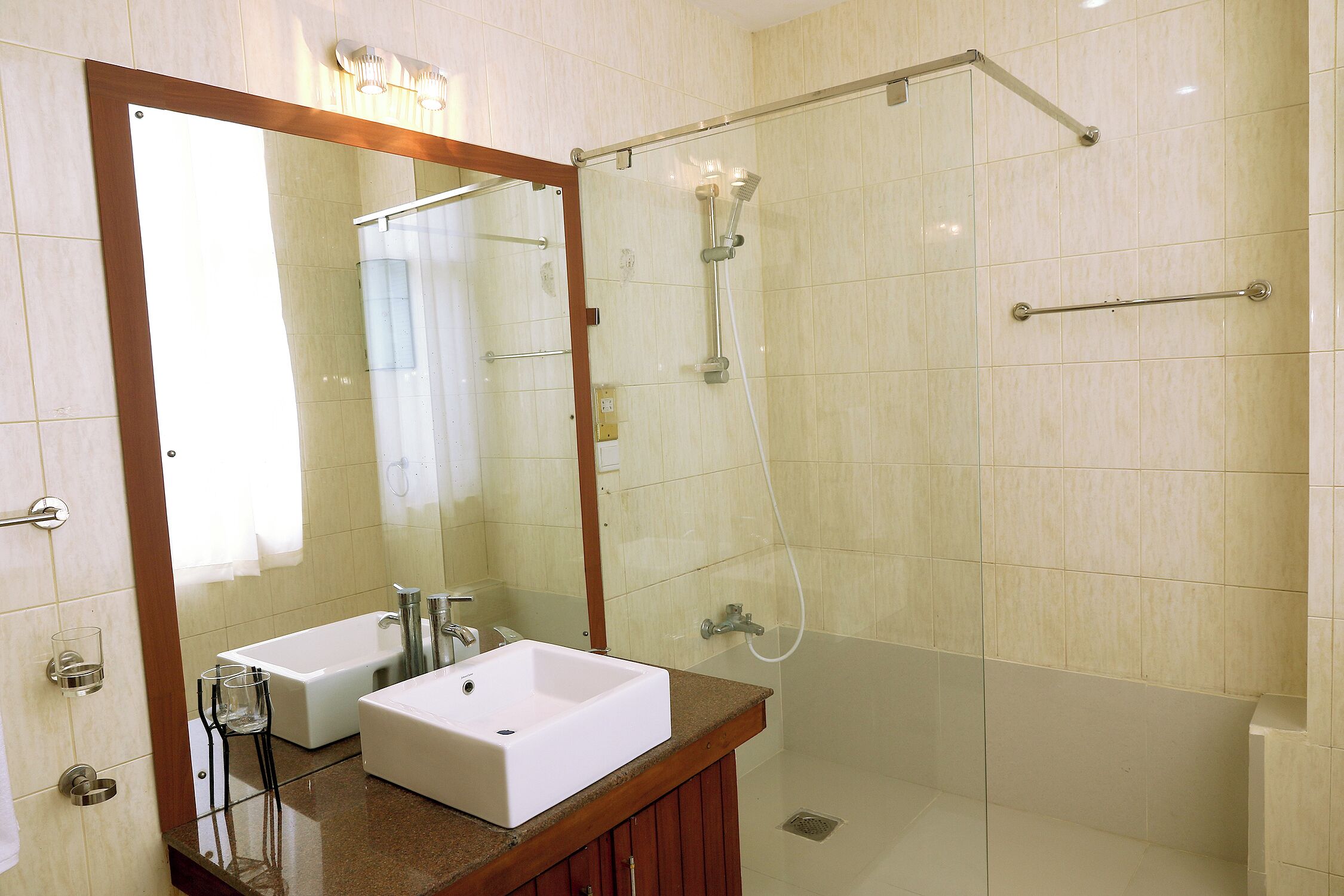 A bathroom with a large mirror, two sinks, a shower, and a bathtub.